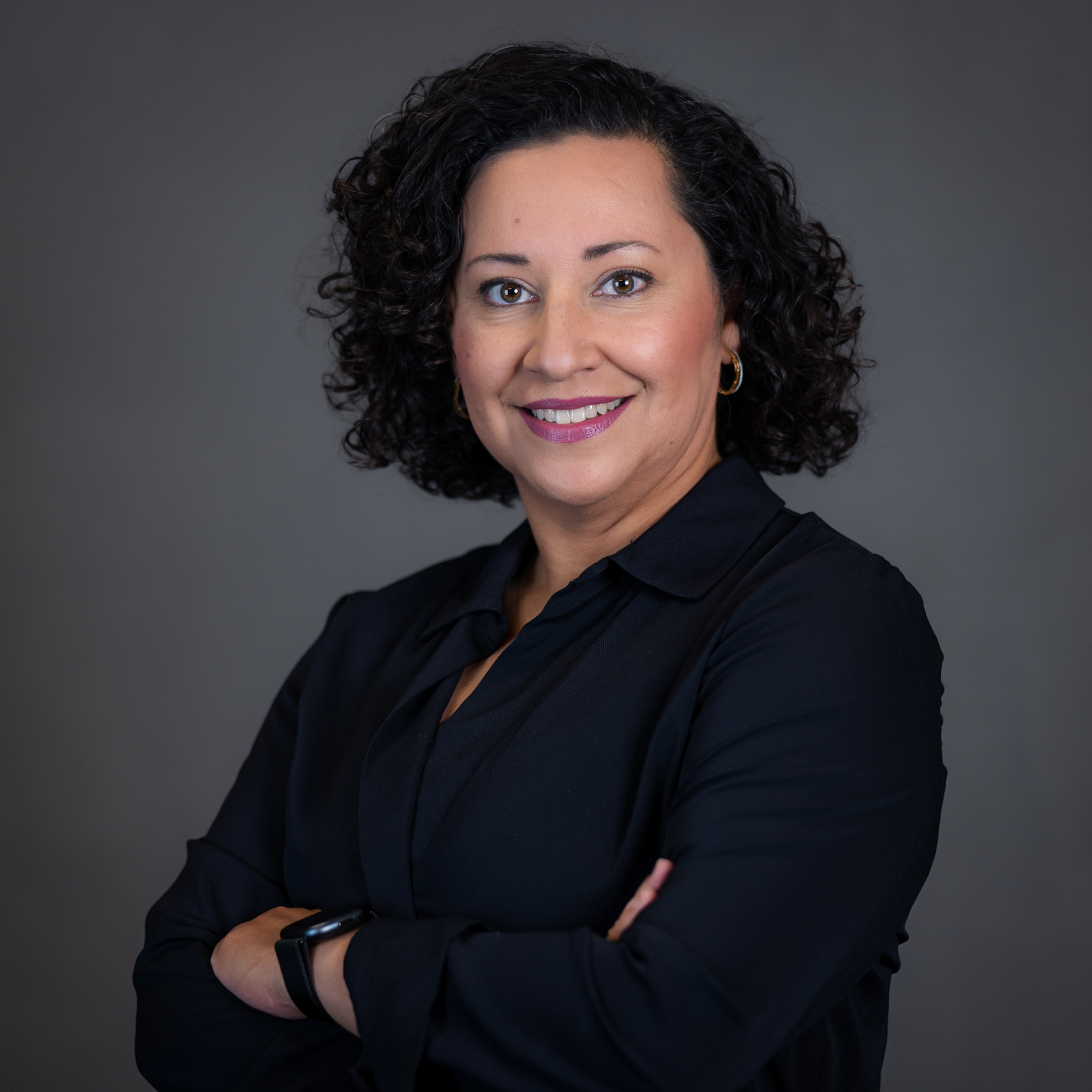 Jennifer Marin Lopez, Director of Human Resources and Culture at TTI Success Insights seen posing for a photo in a dark blue color formal outfit